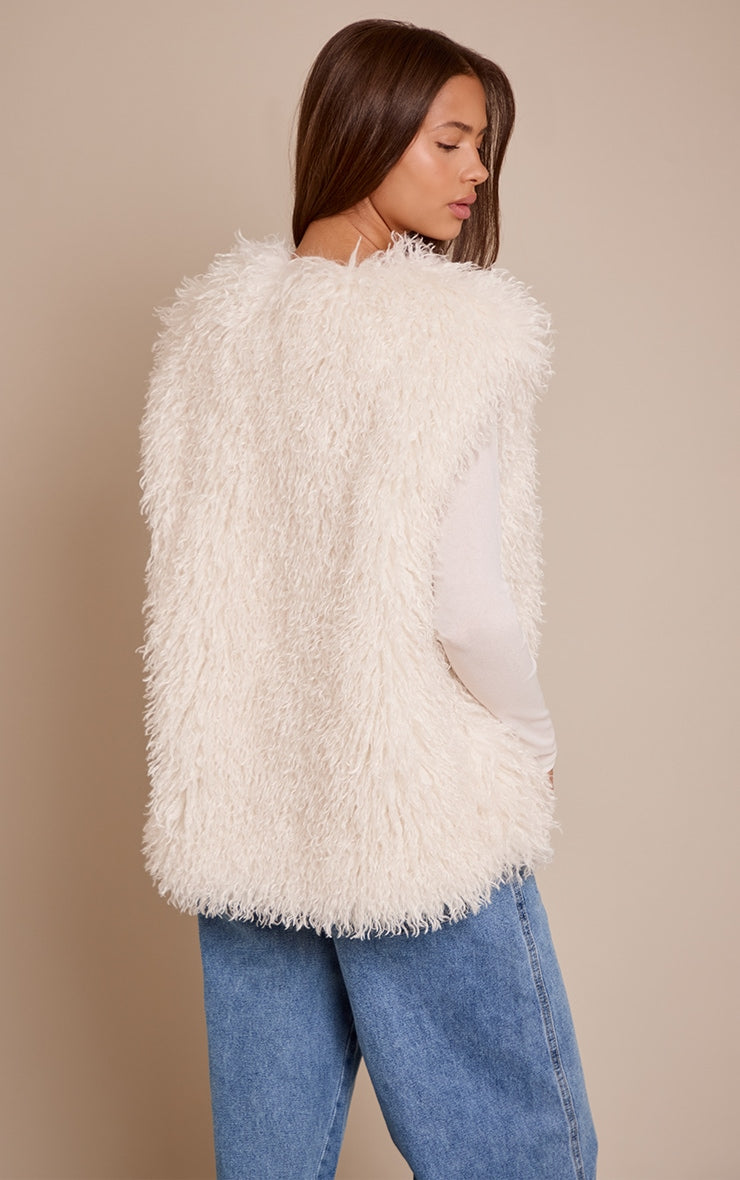 https://cdn-img.prettylittlething.com/5/f/c/7/5fc784fafd77124a2f514be5034e8377c8686855_CNO0270_2_cream_mongolian_faux_fur_gilet.jpg