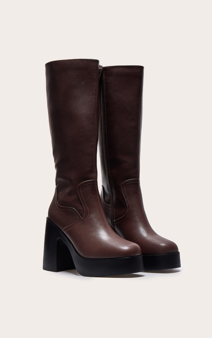 https://cdn-img.prettylittlething.com/6/3/6/5/6365158a159d16dc924ba812f9c87307e7d8bce5_CNL1914_2_chocolate_pu_wide_fit_square_toe_block_heel_slight_platform_knee_high_boots.jpg
