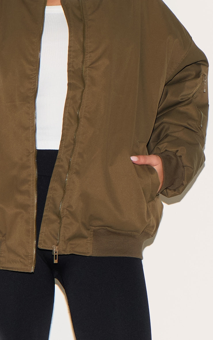 https://cdn-img.prettylittlething.com/7/7/3/9/7739c7be542496767cf0663345b63a095001295c_CNL4138_4_khaki_classic_oversized_bomber_jacket.jpg